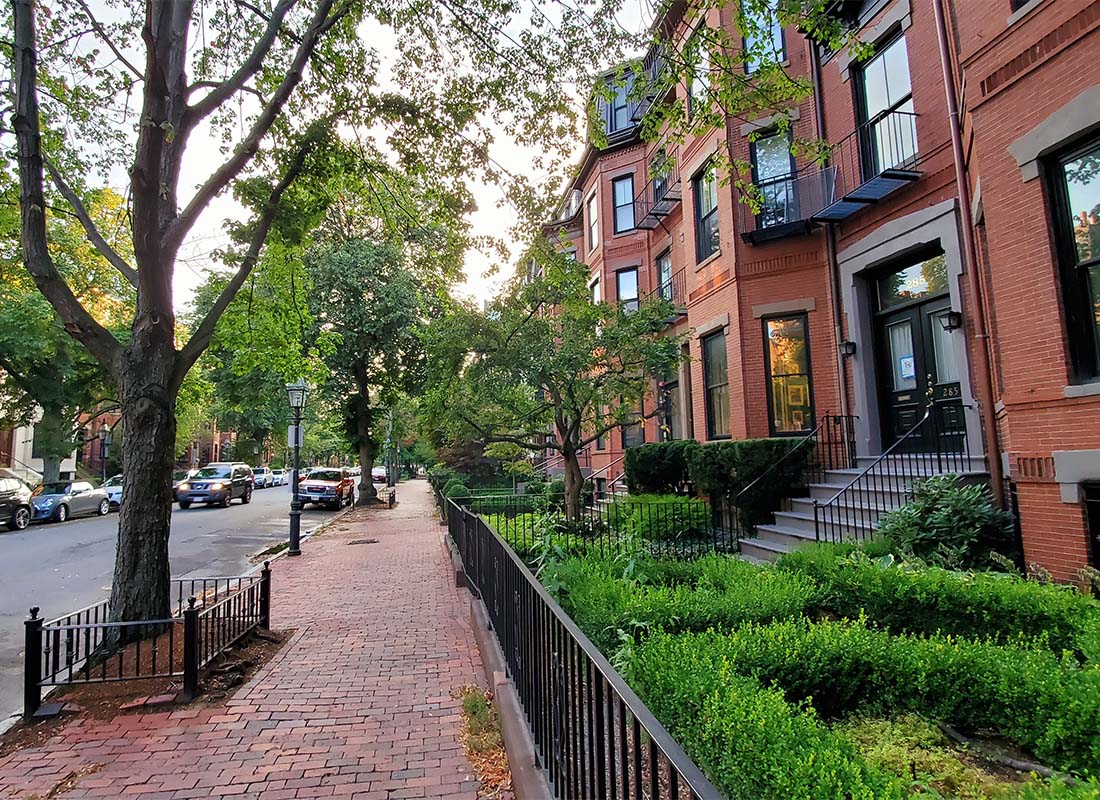 Marlborough, MA - Residential Street in Marlborough Massachusetts with Red Brick Townhomes and Cobblestone Sidewalks with Green Trees