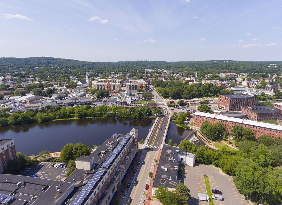 Waltham, MA - Aerial View of Commercial Buildings and Apartments in the Town of Waltham Massachusetts Next to the River Surrounded by Green Trees